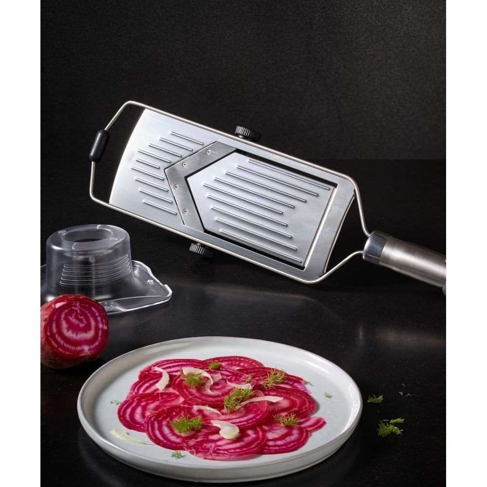 Un carpaccio di barbabietola rossa con mandolina e mezza barbabietola.