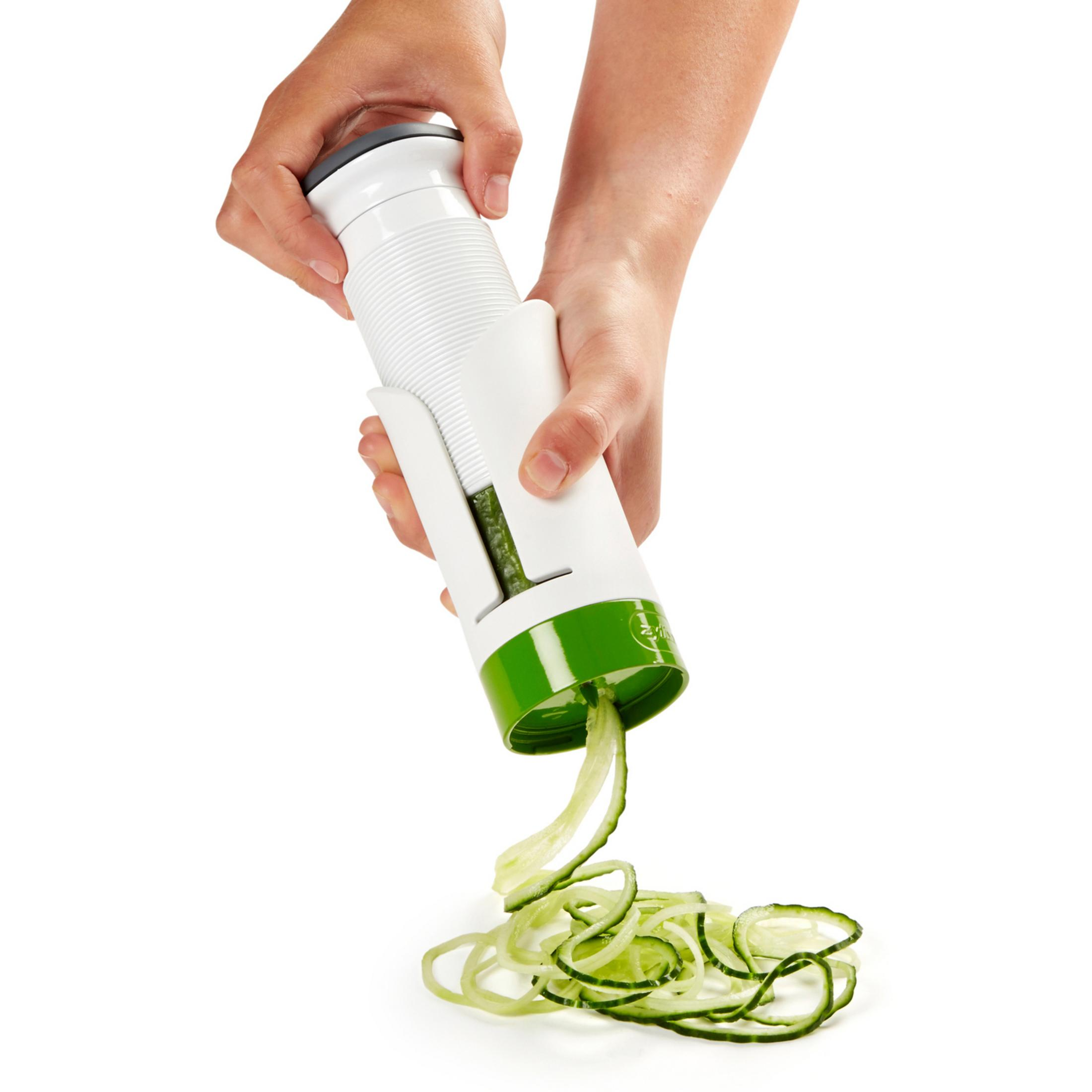Mani che tengono uno spiralizer che taglia cetrioli a spirale.