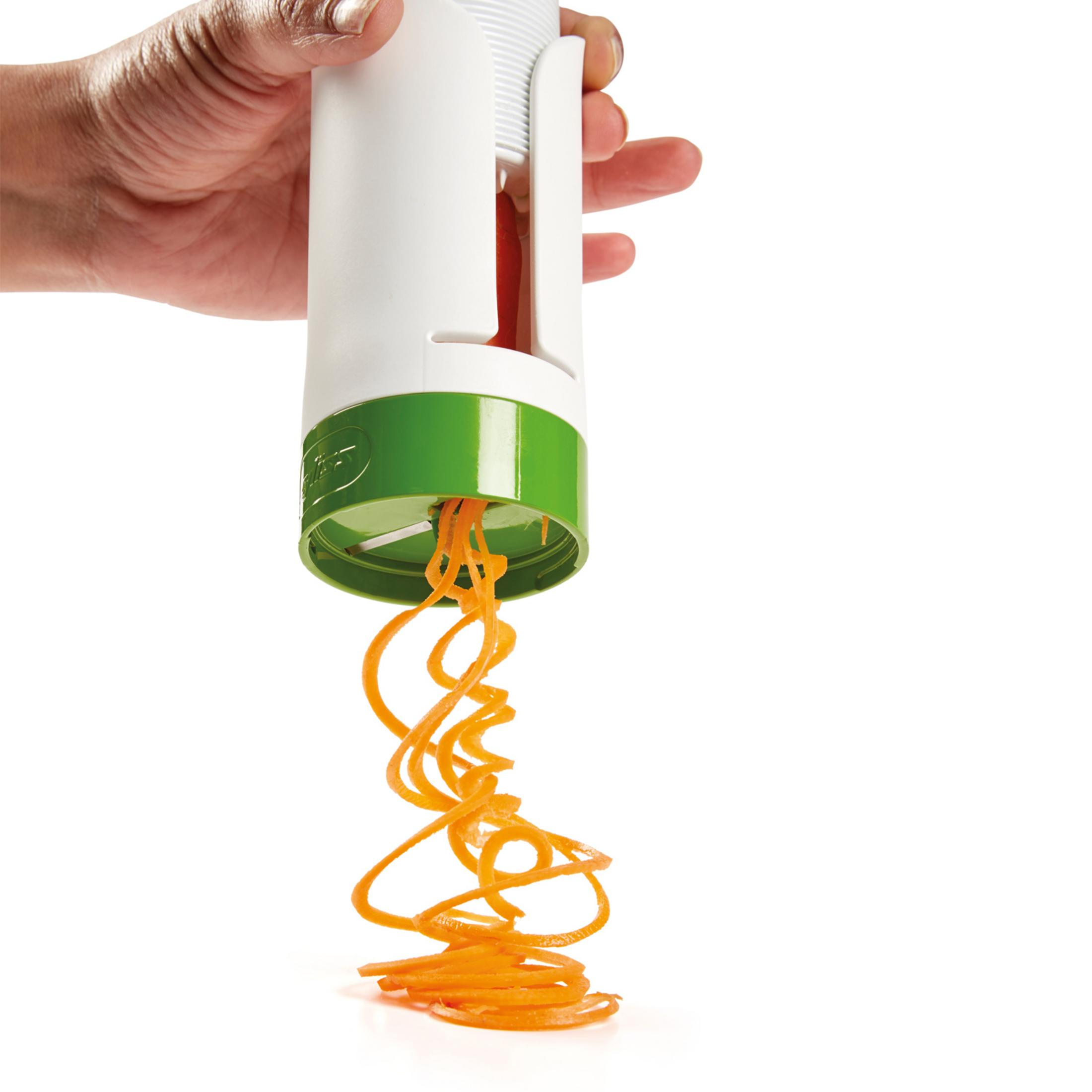 Una mano tiene uno spiralizer che taglia strisce di carota. Colori bianco e verde.