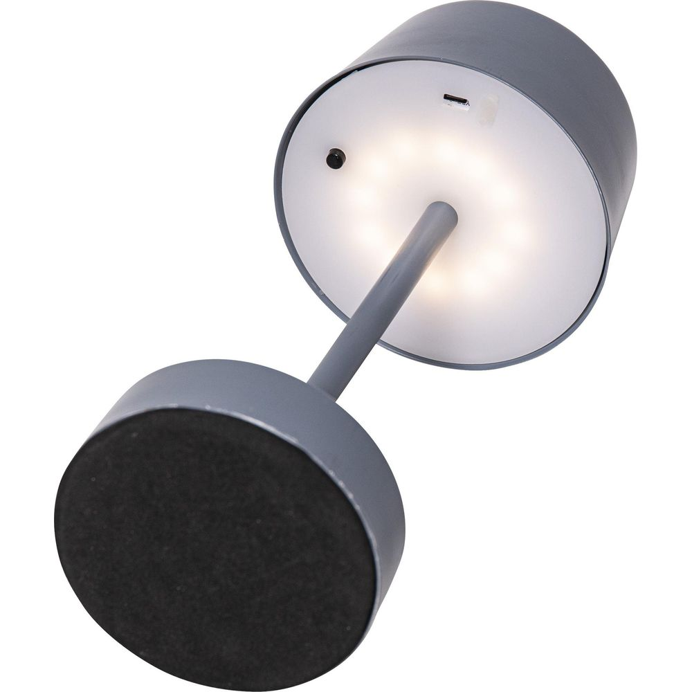 Lampada grigia con base rotonda e paralume illuminato.
