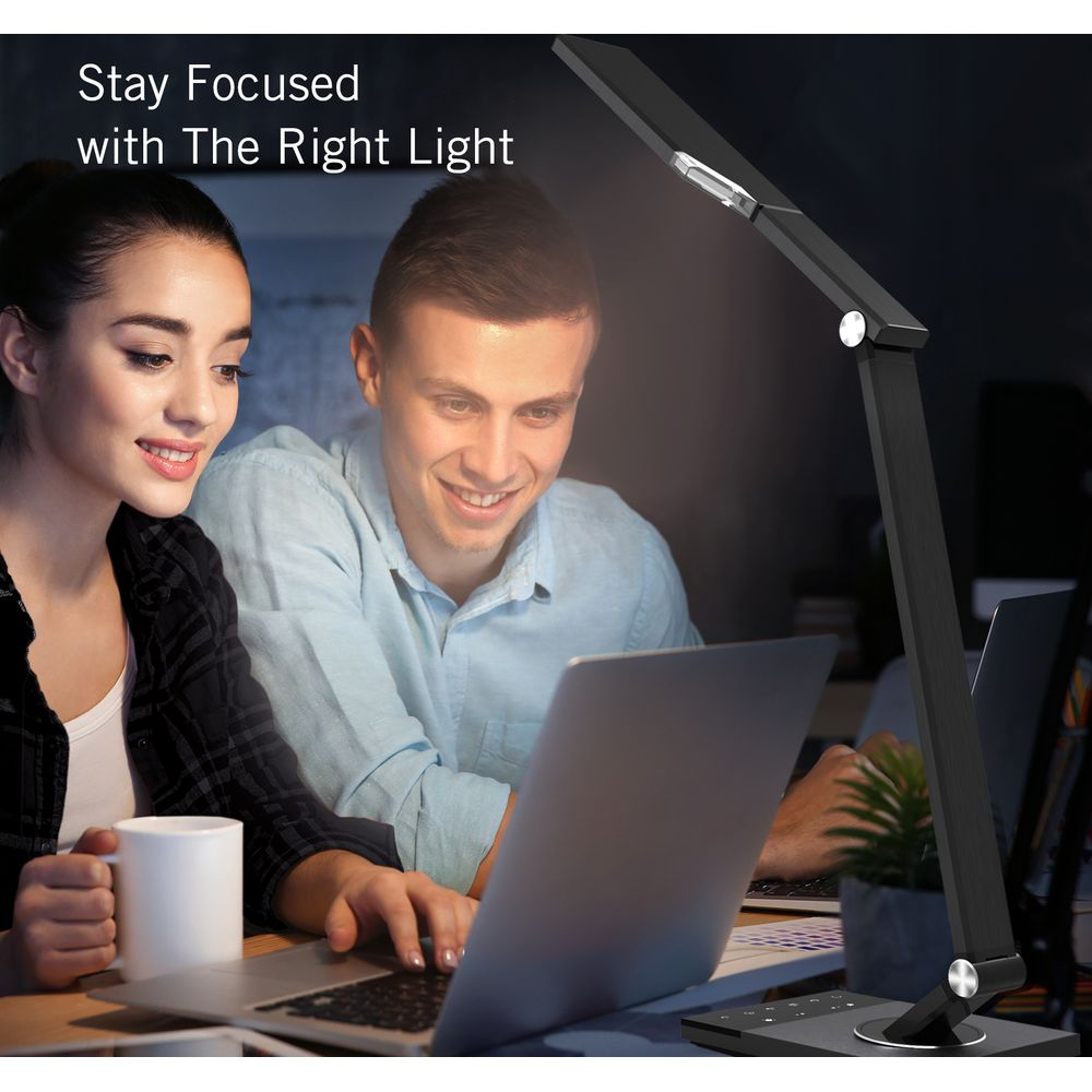 Mann und Frau arbeiten am Schreibtisch mit Laptop und Schreibtischlampe.