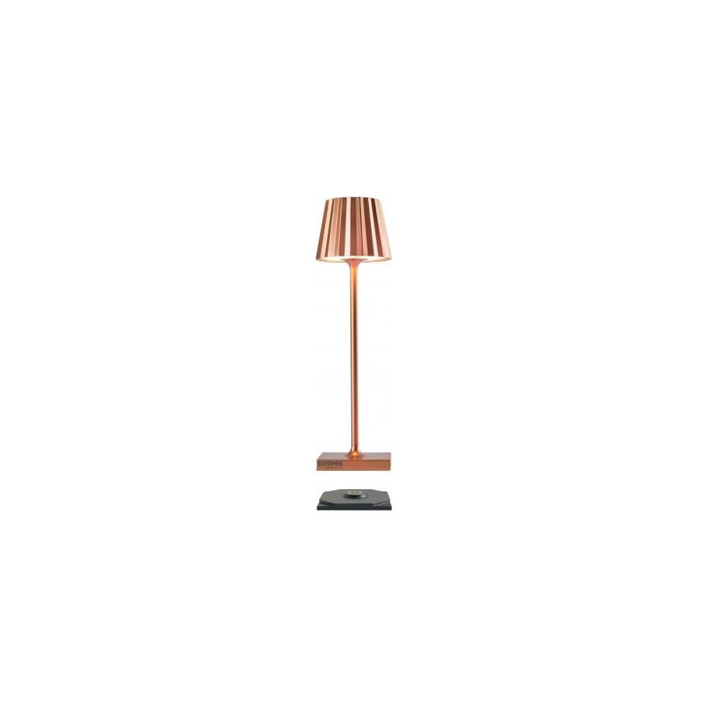 Eine kupferfarbene Tischlampe mit geripptem Lampenschirm steht auf einem Sockel.