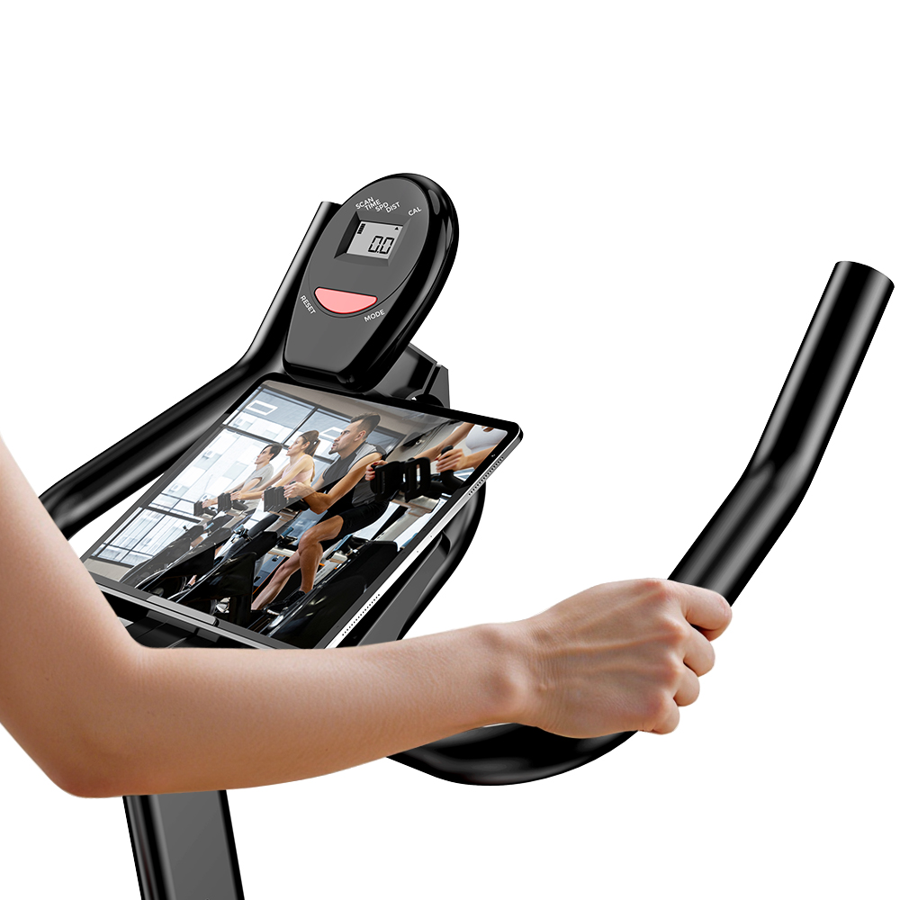 Person auf einem Heimtrainer, die auf einen Bildschirm schaut, der Radfahrer zeigt.