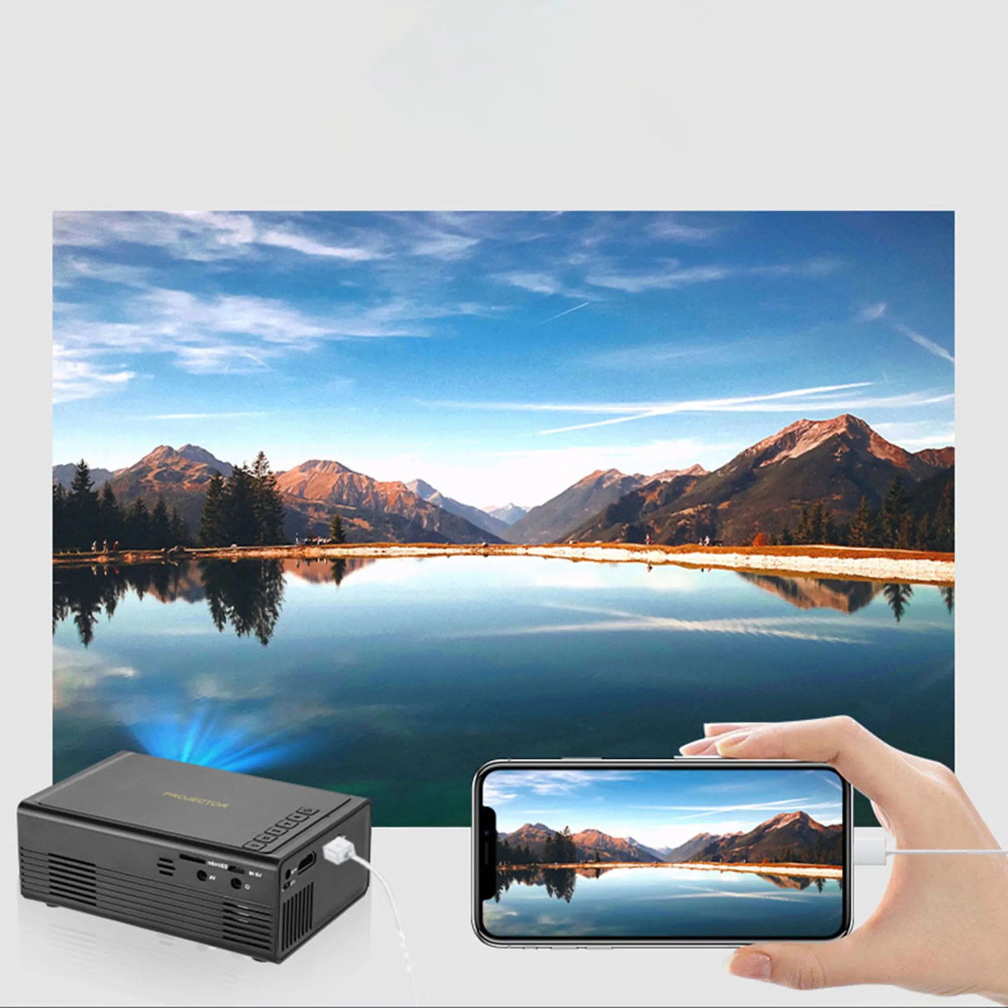 Ein schwarzer Projektor spiegelt ein Bergsee-Bild auf einem Smartphone ab.