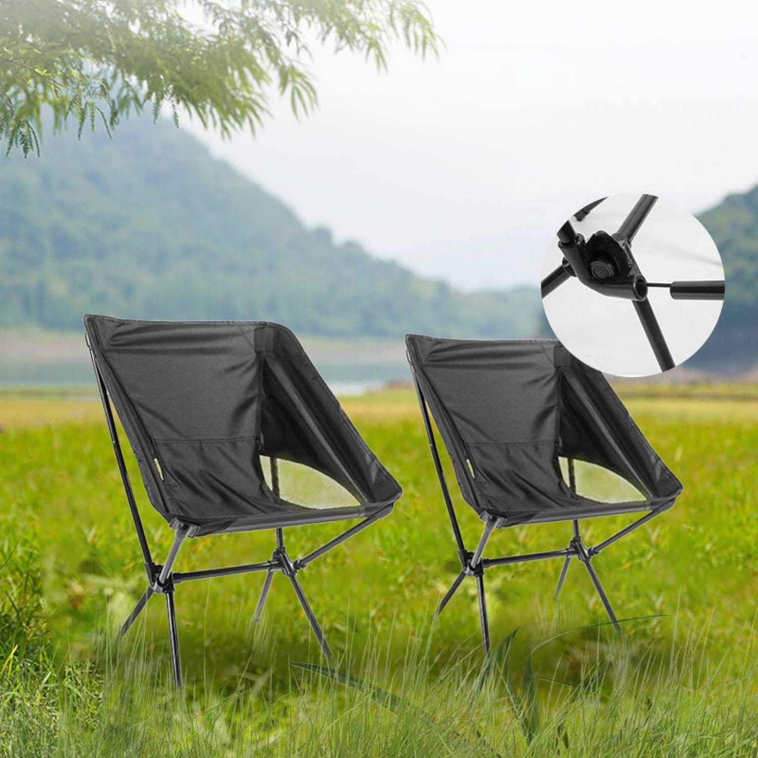 Zwei schwarze Campingstühle stehen auf grünem Gras. Ein Detail der Verbindungsstücke ist zu sehen.