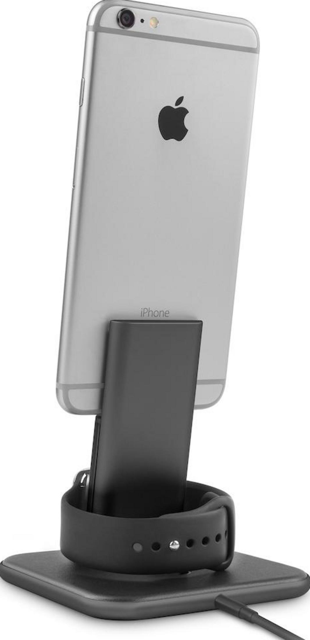 Un iPhone argentato è su una base di ricarica nera con un Apple Watch.