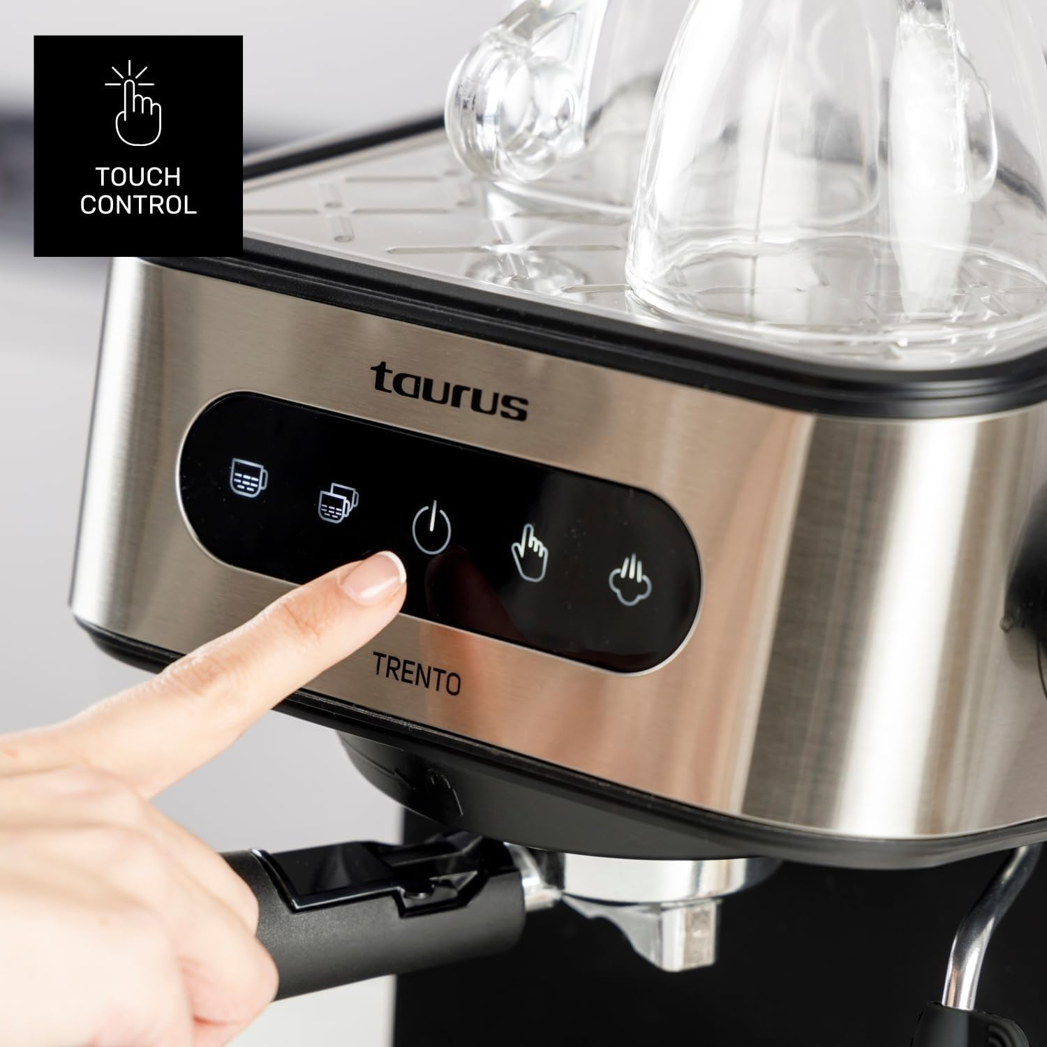 Una mano presiona la pantalla táctil de una cafetera Taurus.