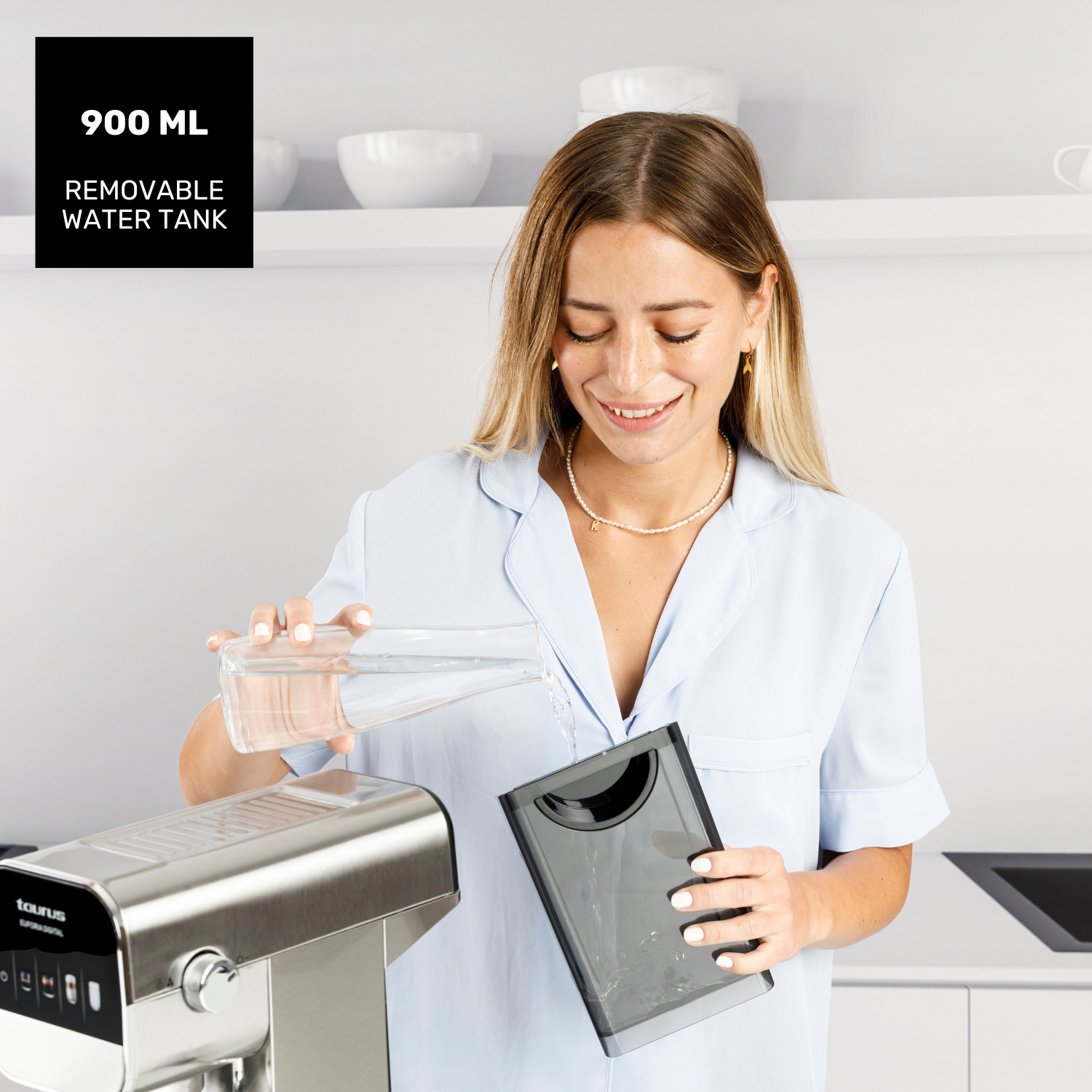 Una mujer vierte agua en el depósito de agua extraíble de una máquina.