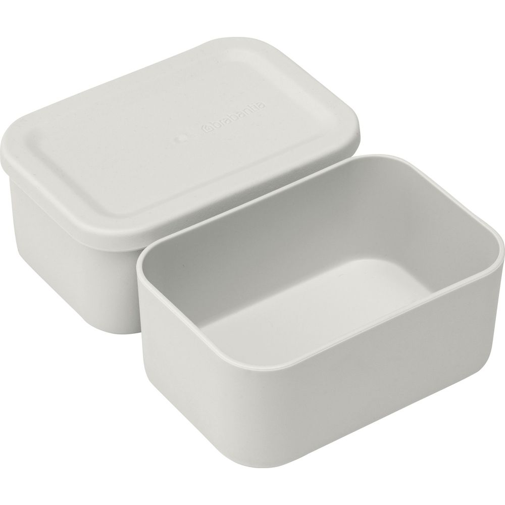 Un contenitore rettangolare grigio chiaro con il coperchio socchiuso. Sfondo bianco.