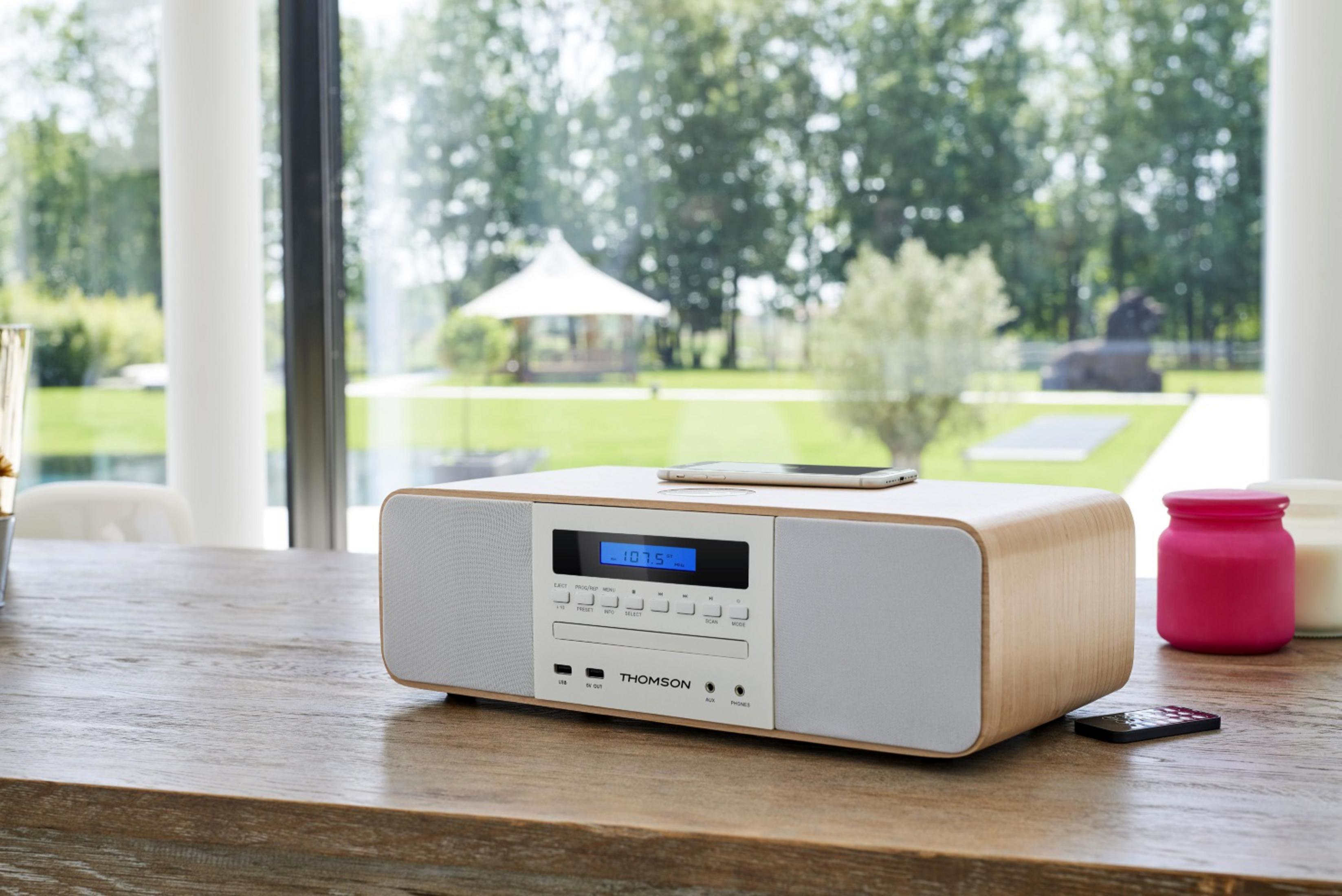 Drewniane radio z odtwarzaczem CD i niebieskim wyświetlaczem na drewnianym stole.