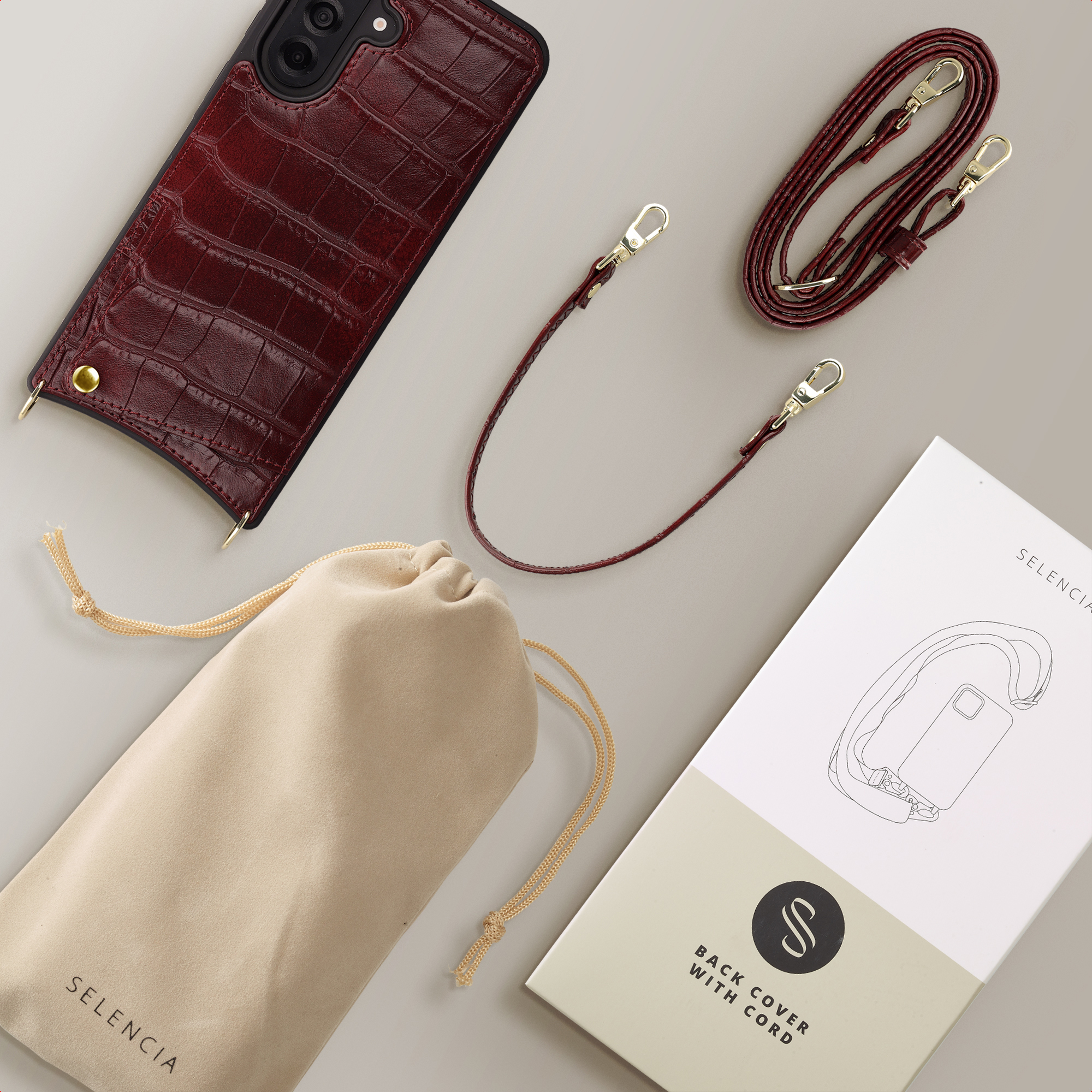 Donkerrode krokodillenleren telefoonhoes met koord en buidel.