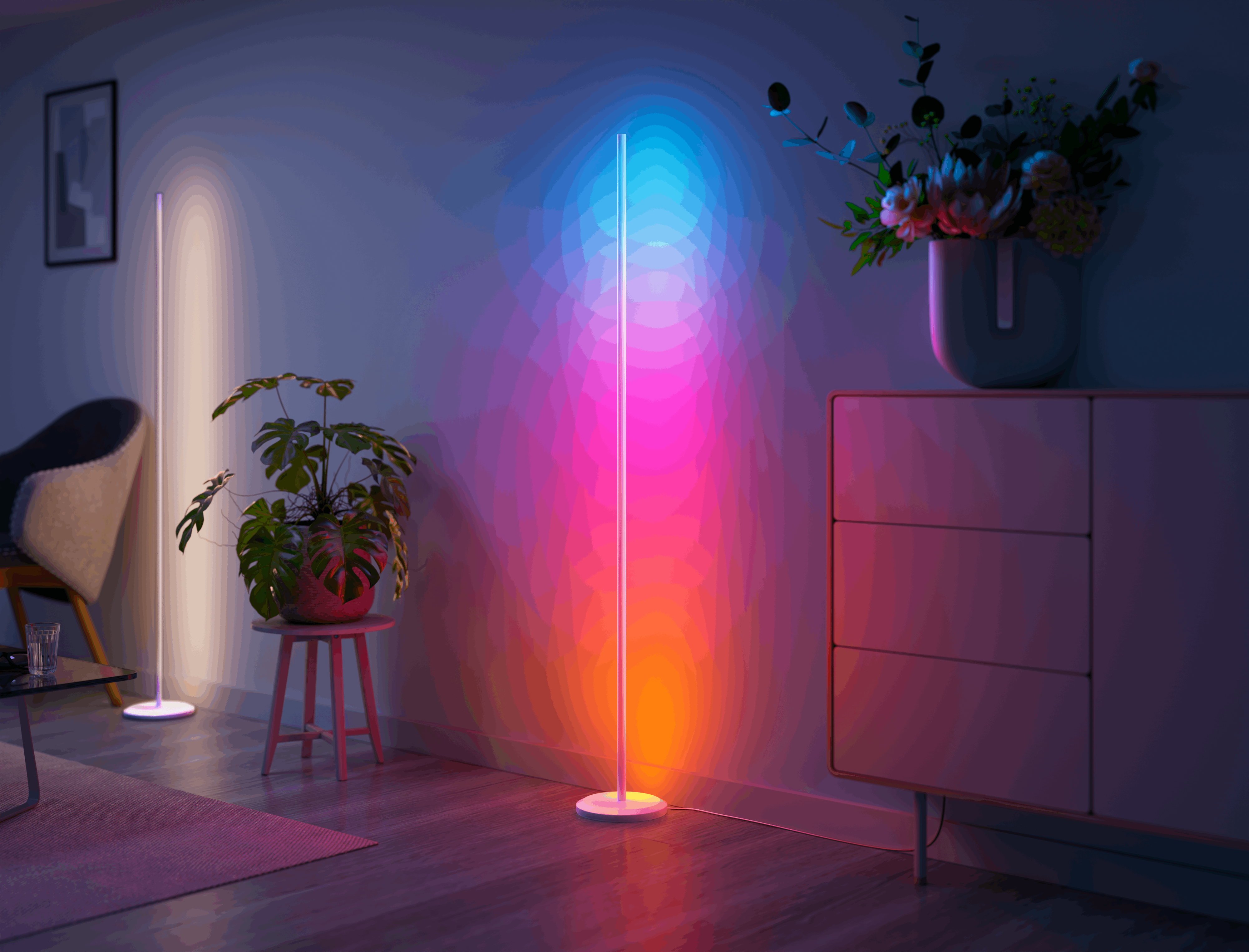 Lampade da terra colorate illuminano una stanza con poltrona, tavolo e pianta.