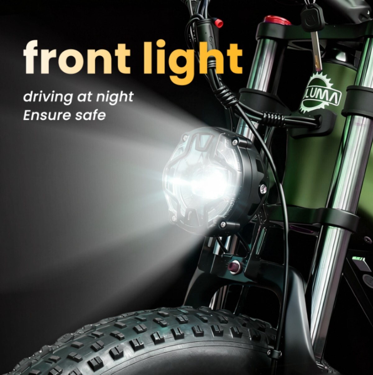 Jasny reflektor rowerowy świeci, pokazując szeroką oponę i amortyzację.