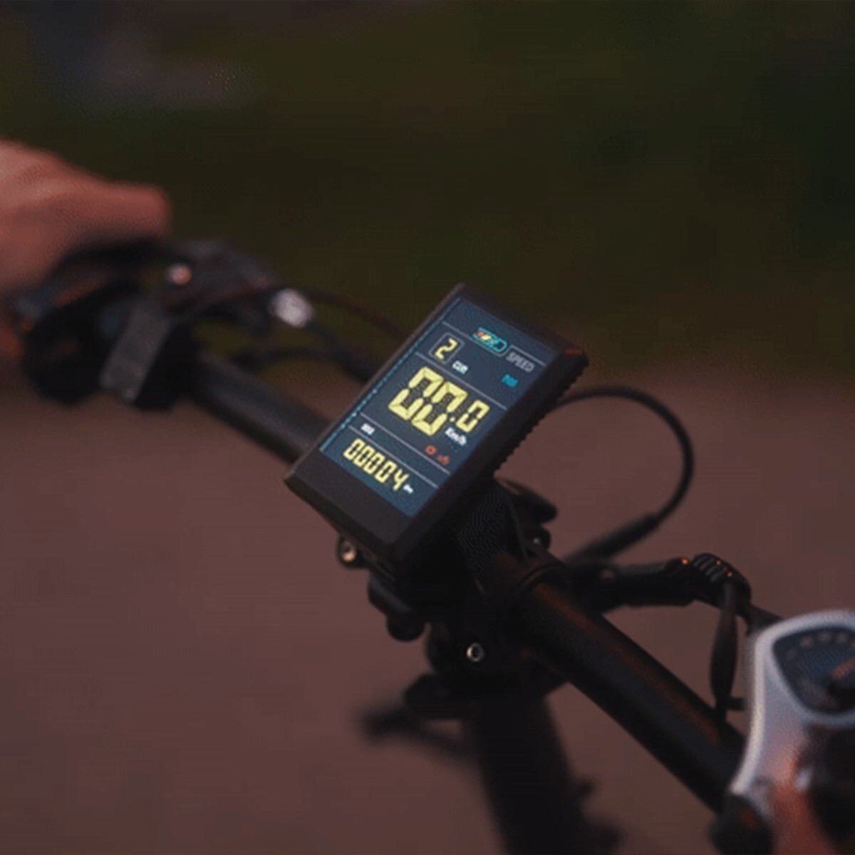 Kierownica roweru z cyfrowym wyświetlaczem pokazującym 00,0 km/h i 0004 km.