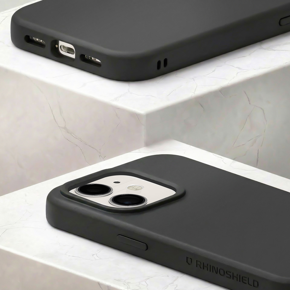 Gros plan d'une coque de téléphone gris foncé avec découpe caméra et port de charge visibles.