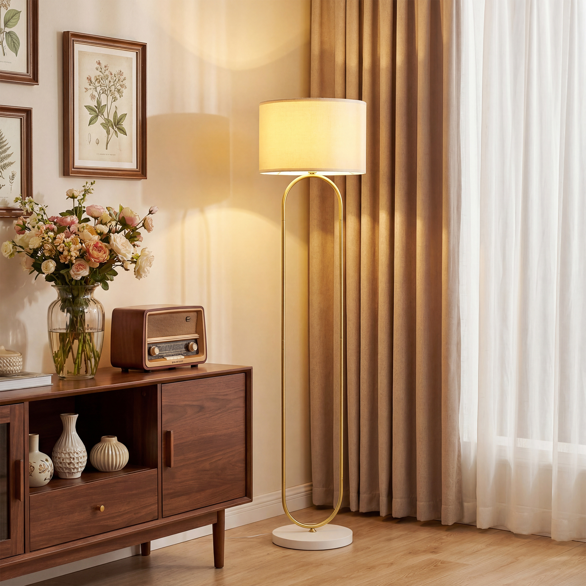 Una base di lampada da terra moderna con cornice ovale in ottone accanto a un mobile in legno.