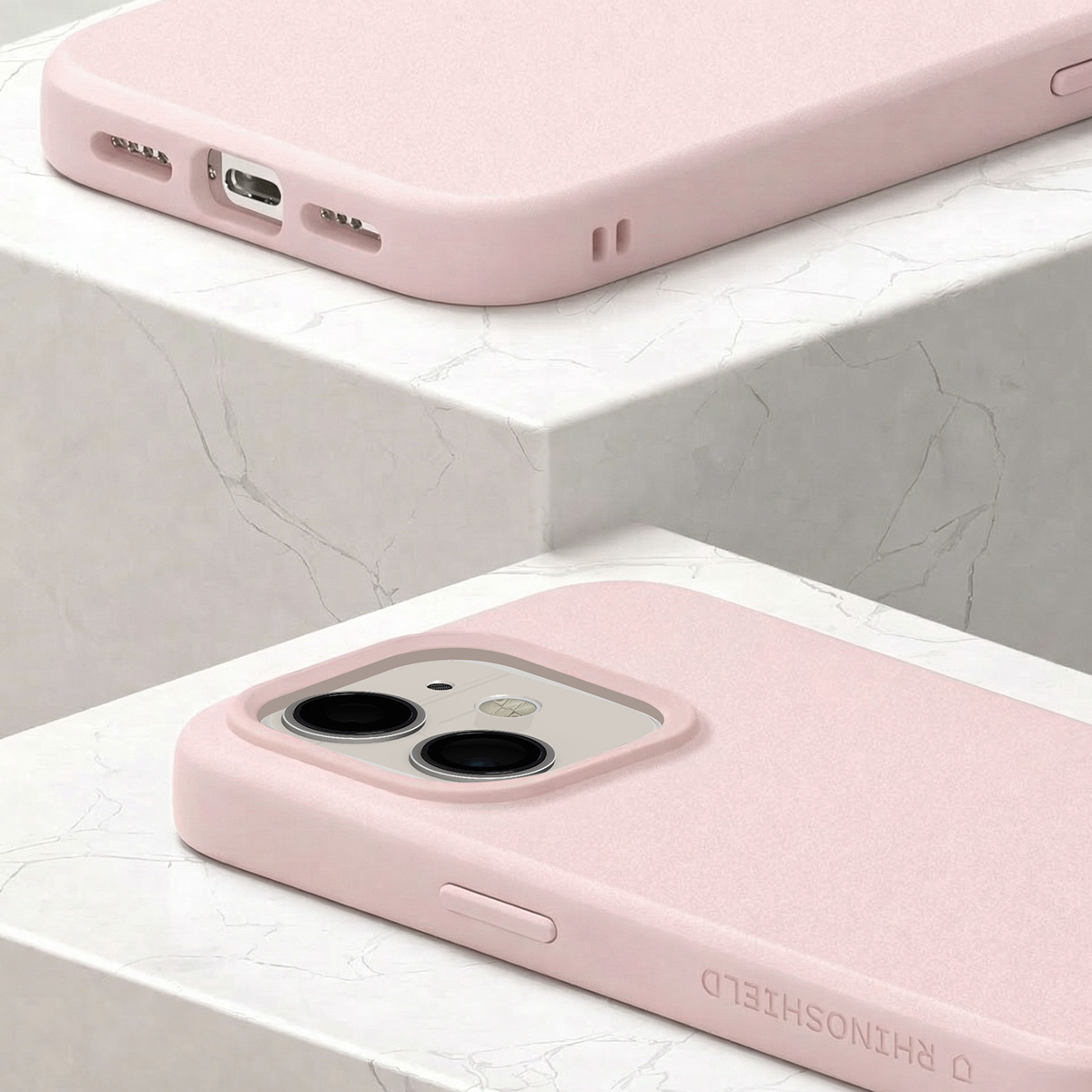 Twee roze telefoonhoesjes op marmer, de ene toont camera, de andere oplaadpoort.