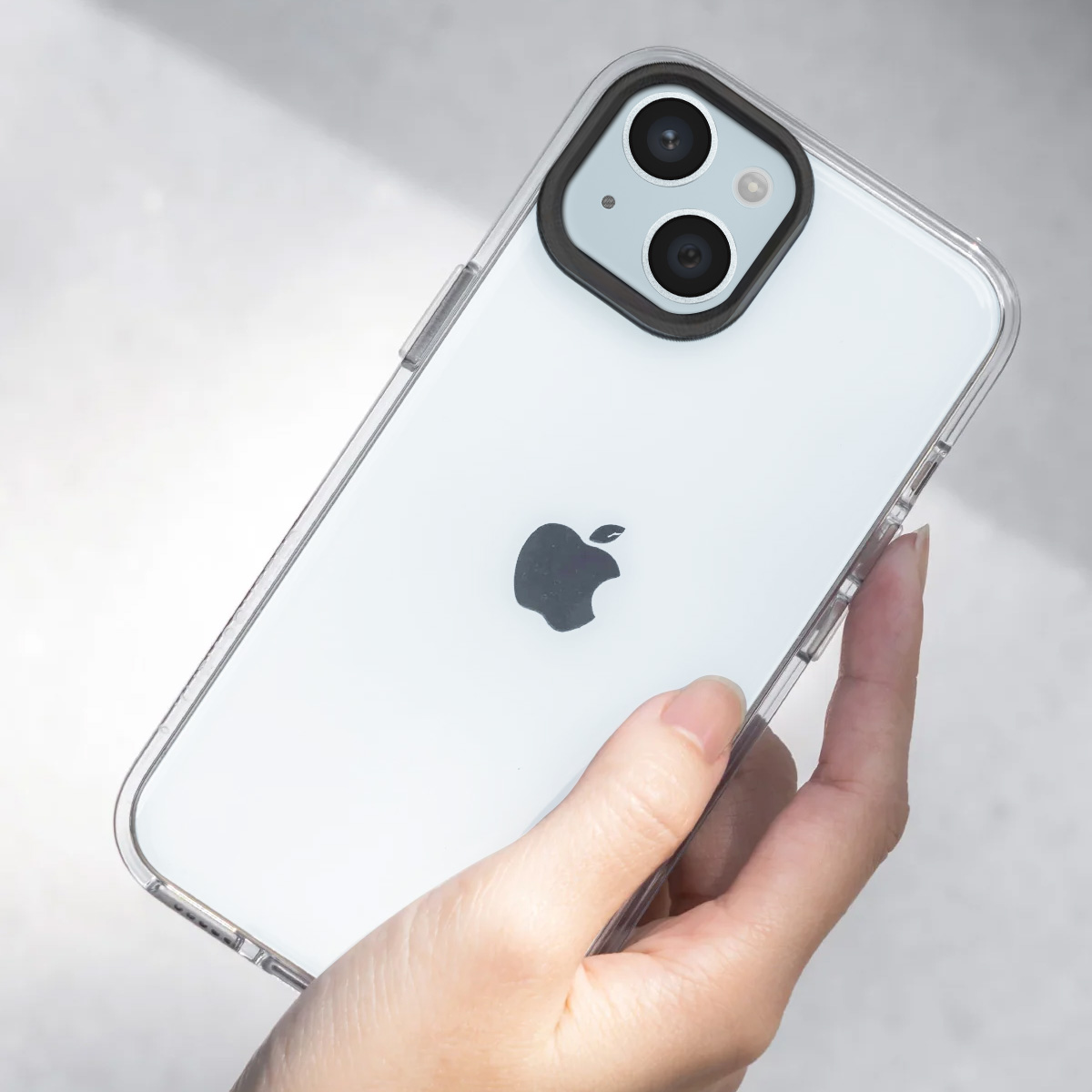 Een hand houdt een witte iPhone met doorzichtige hoes vast, met twee camera's.