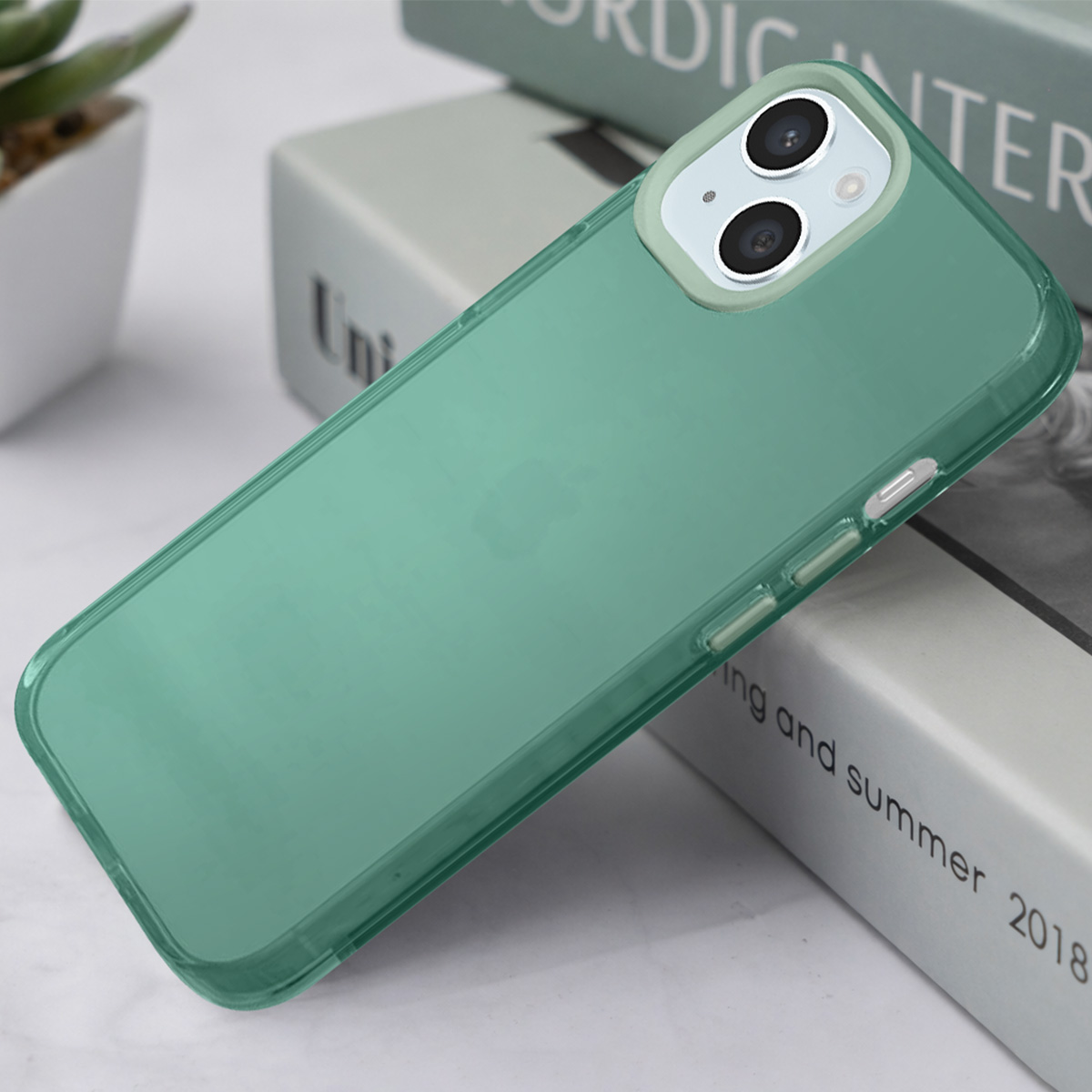 Coque de téléphone verte avec découpe double caméra sur des livres.