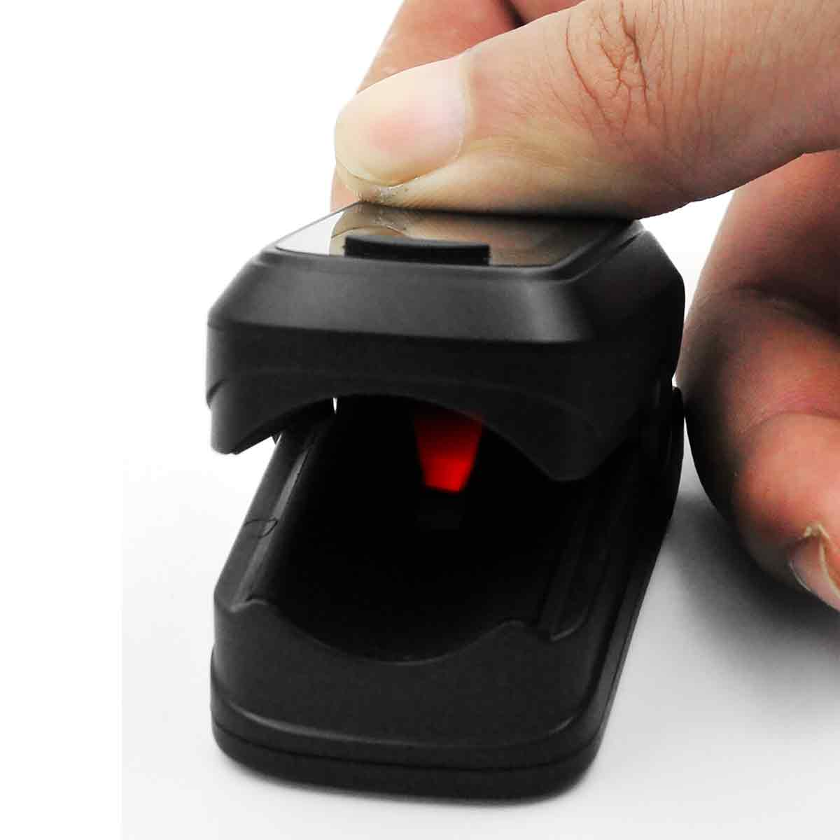Ein Finger drückt auf einen schwarzen Pulsoximeter-Clip mit rotem Licht.