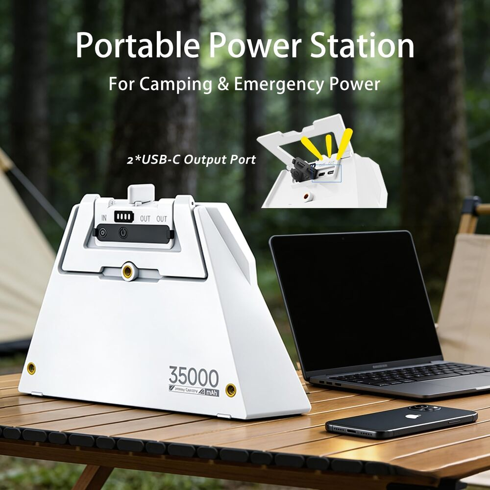 Weiße tragbare Powerstation mit 35000mAh, Laptop und Handy auf Holztisch im Freien.