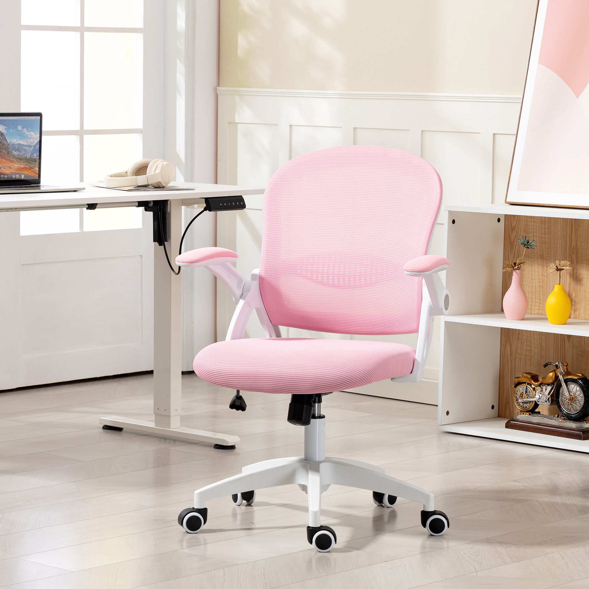 Una sedia da ufficio rosa con ruote è davanti a una scrivania e una mensola.