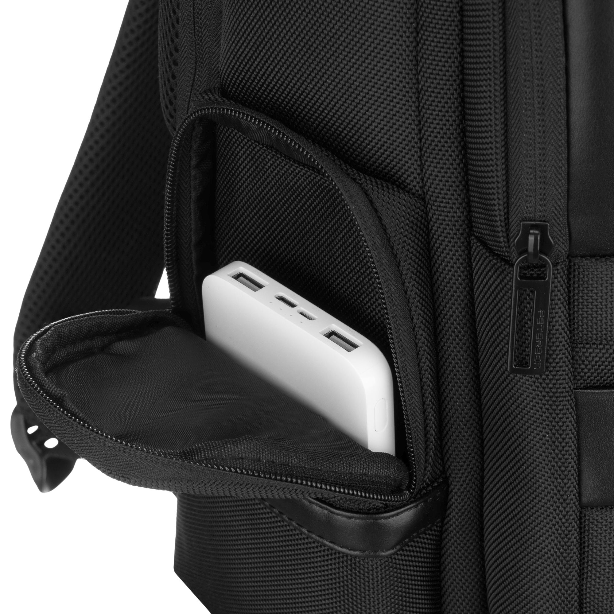 Bia'y power bank jest wsuwany do otwartej kieszeni czarnego plecaka.