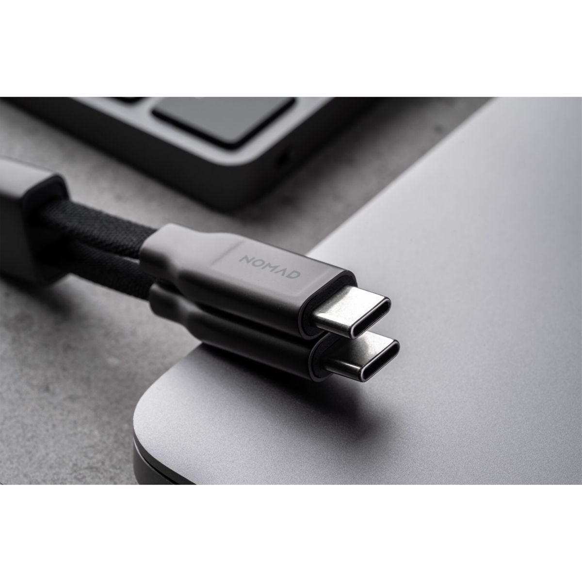 Due cavi USB-C Nomad con cavi intrecciati si collegano a un dispositivo argentato.