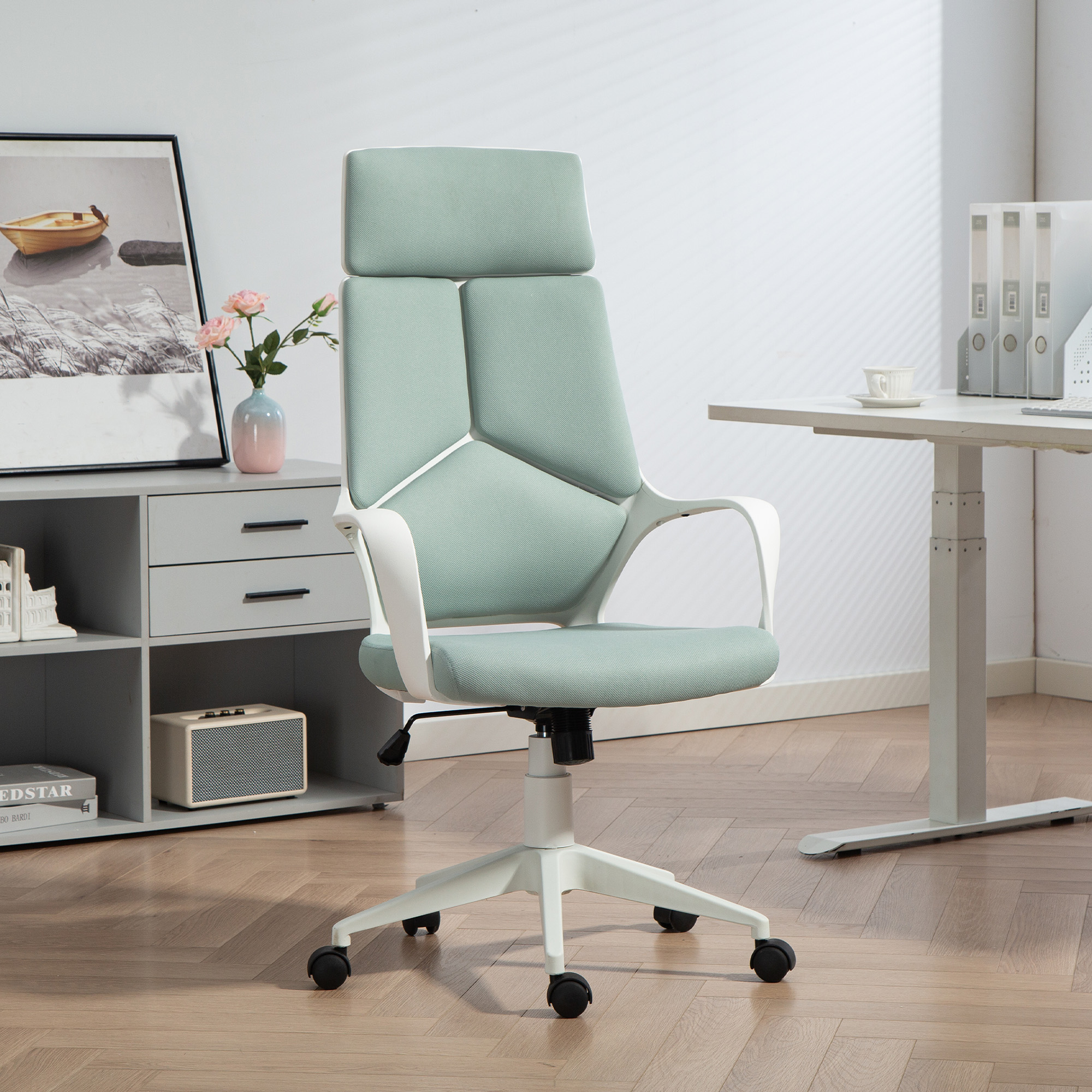 Una sedia da ufficio verde menta con telaio bianco su pavimento in legno.