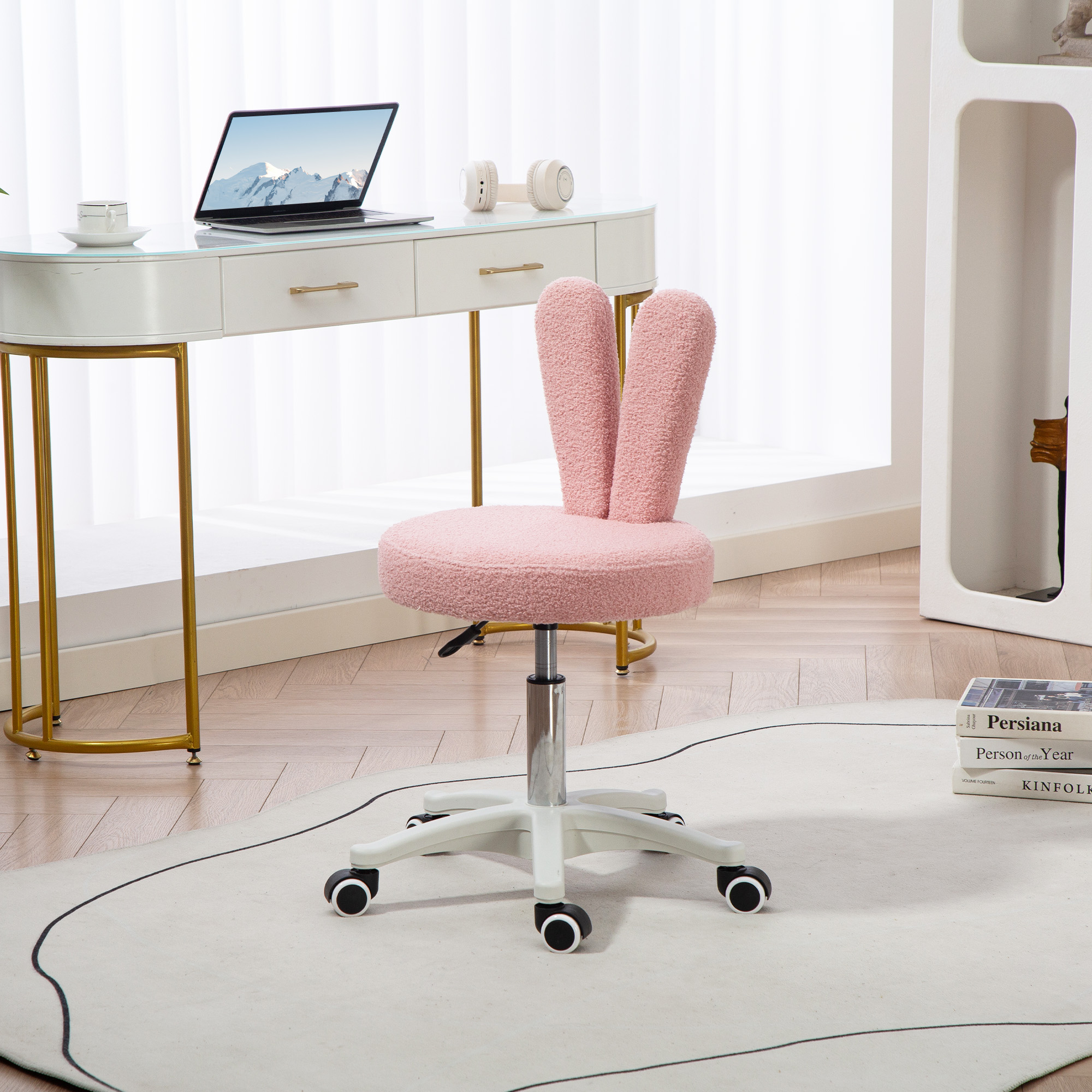 Una sedia da scrivania rosa teddy con orecchie da coniglio su un tappeto bianco.