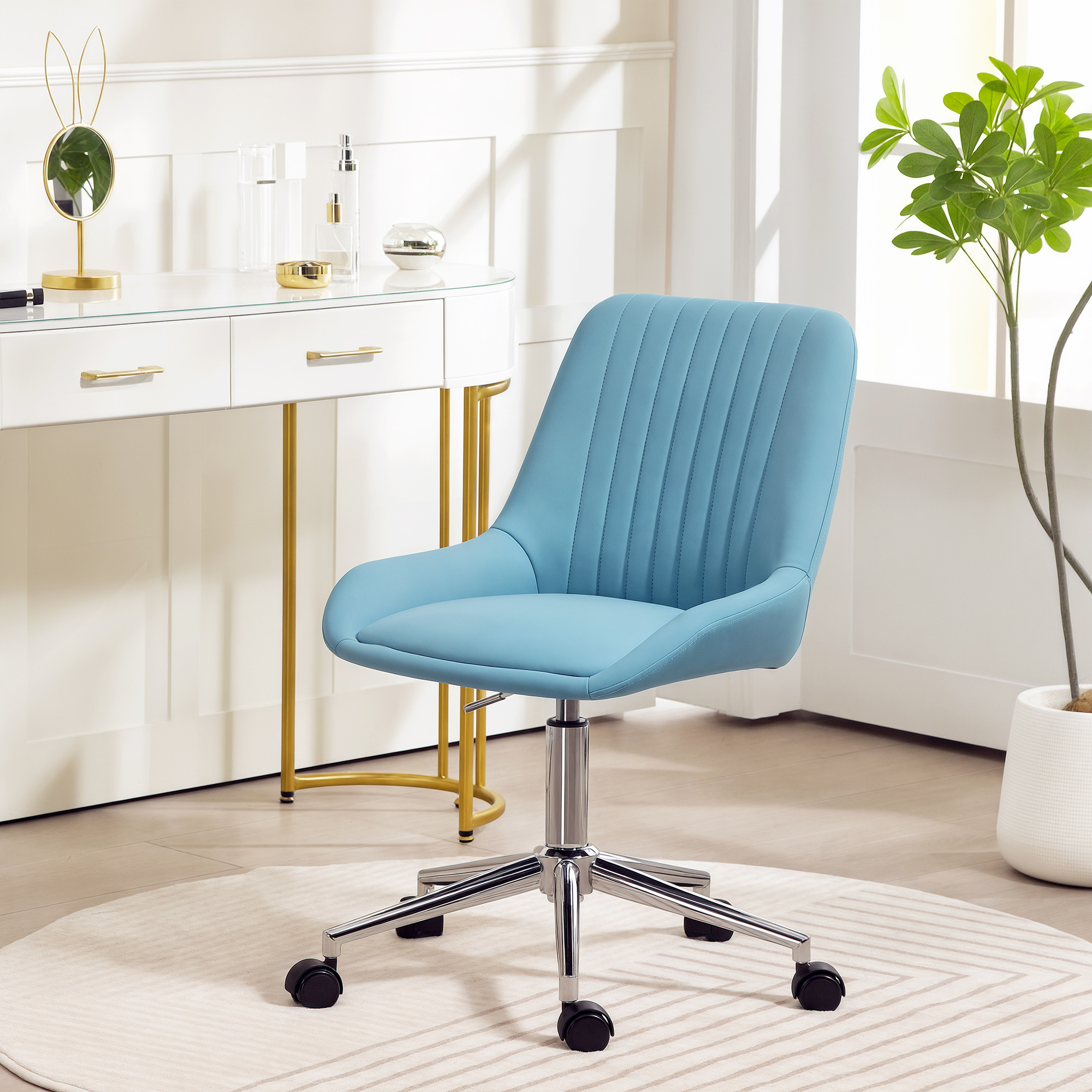Una sedia da ufficio blu siede davanti a una toeletta bianca con accenti dorati.