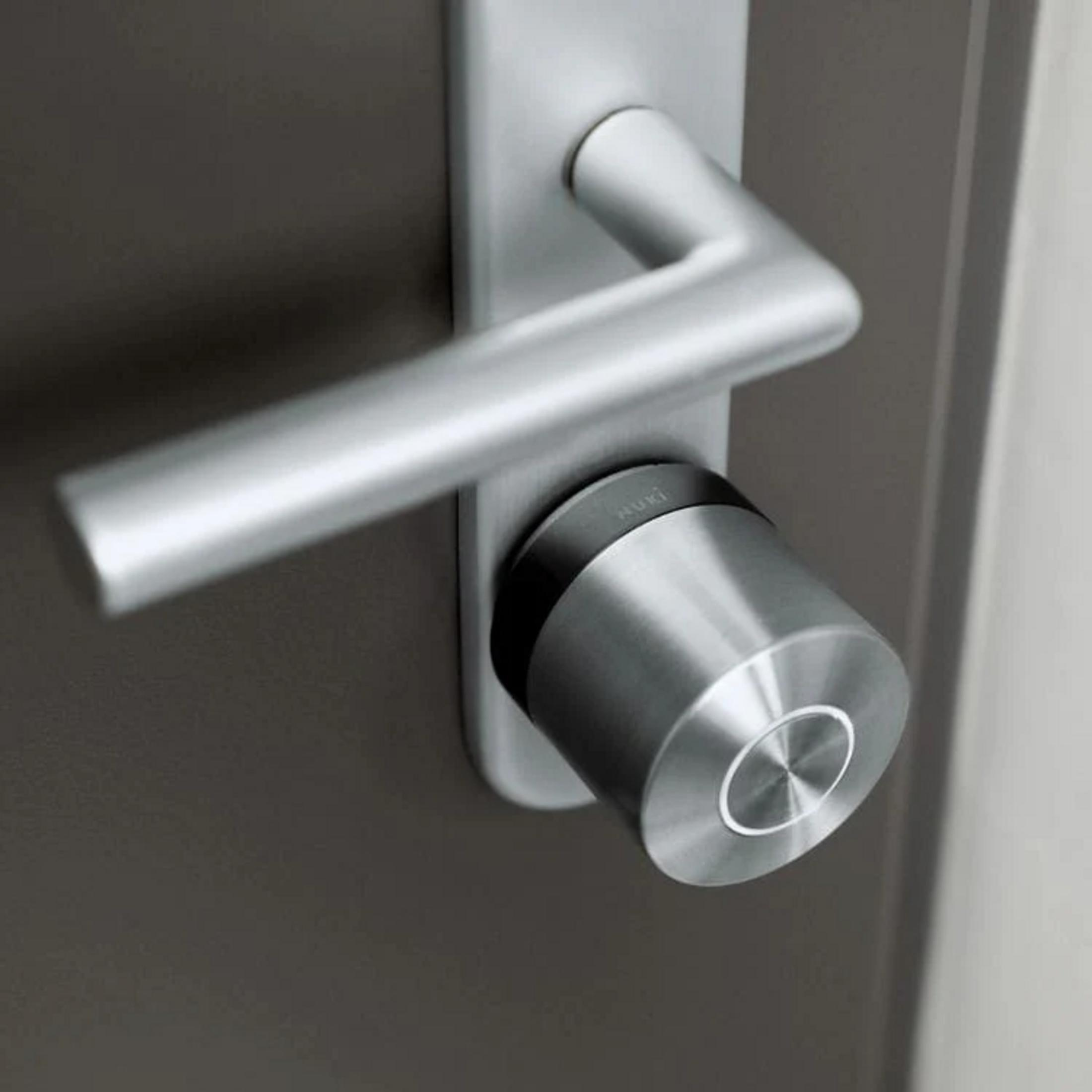 Manija de puerta plateada moderna con un accesorio de cerradura inteligente.