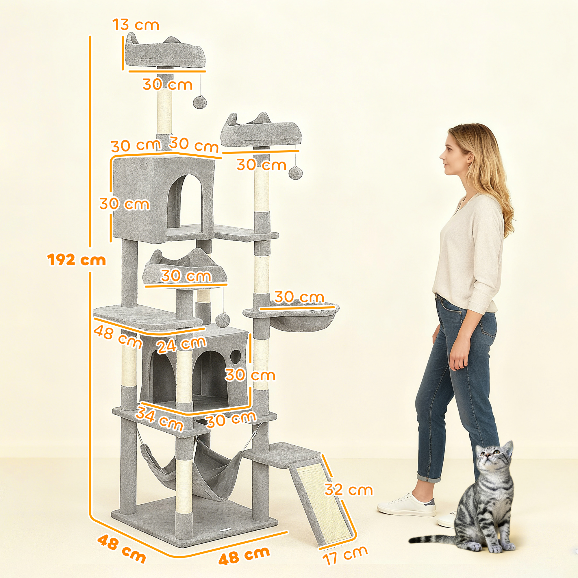 Tiragraffi grigio alto con amaca, piattaforme, case e giocattoli. Una donna e un gatto vicini.