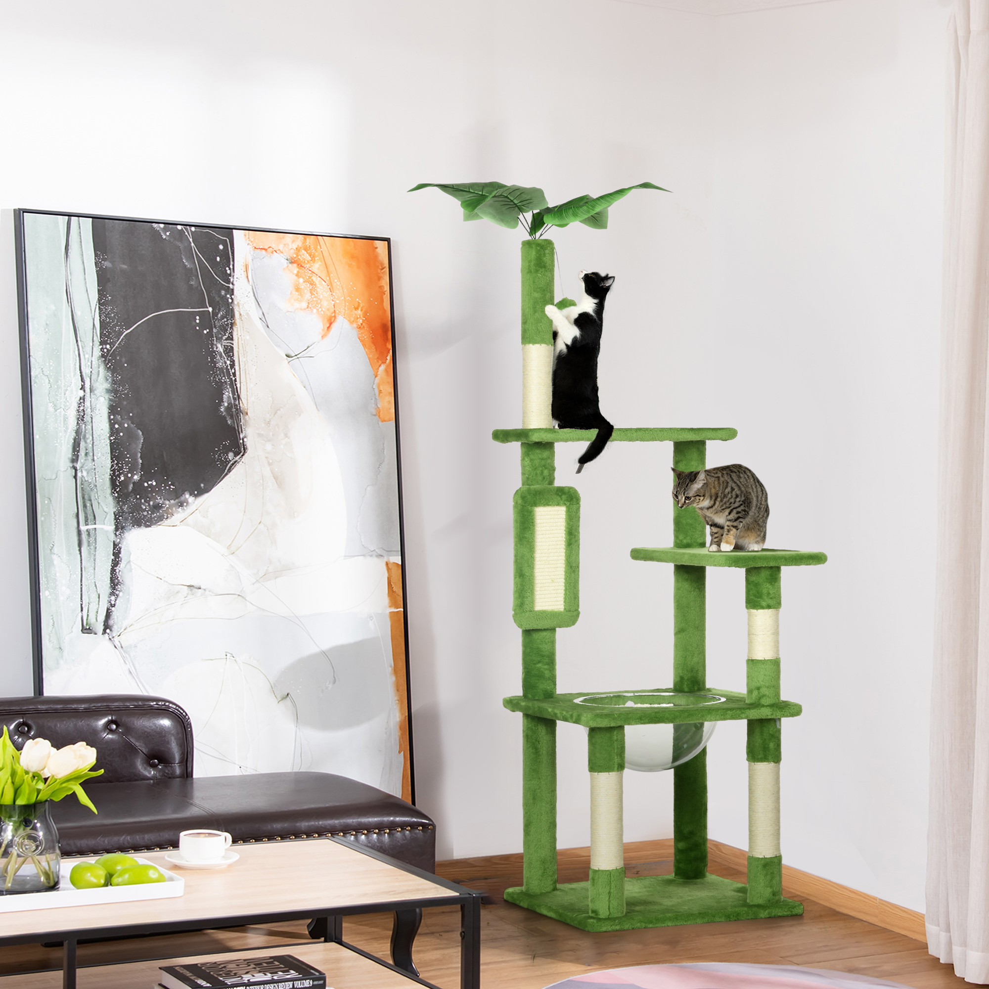 Due gatti su un tiragraffi verde in un soggiorno con un dipinto.