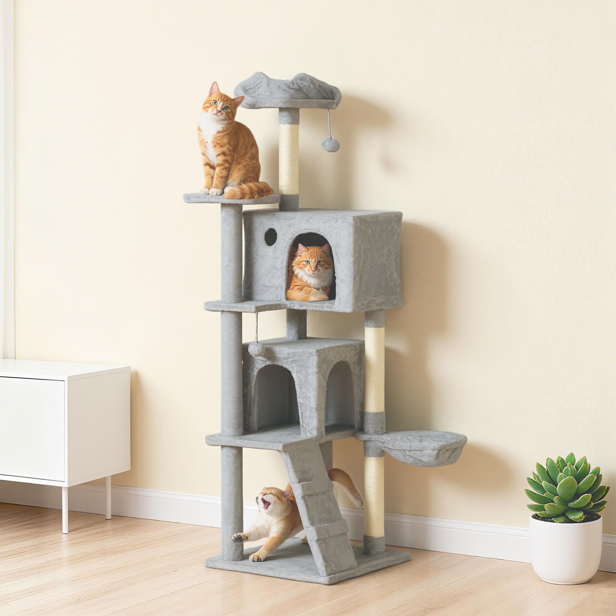 Tre gatti su un tiragraffi grigio. Uno in cima, uno nella cuccia, uno si stiracchia.