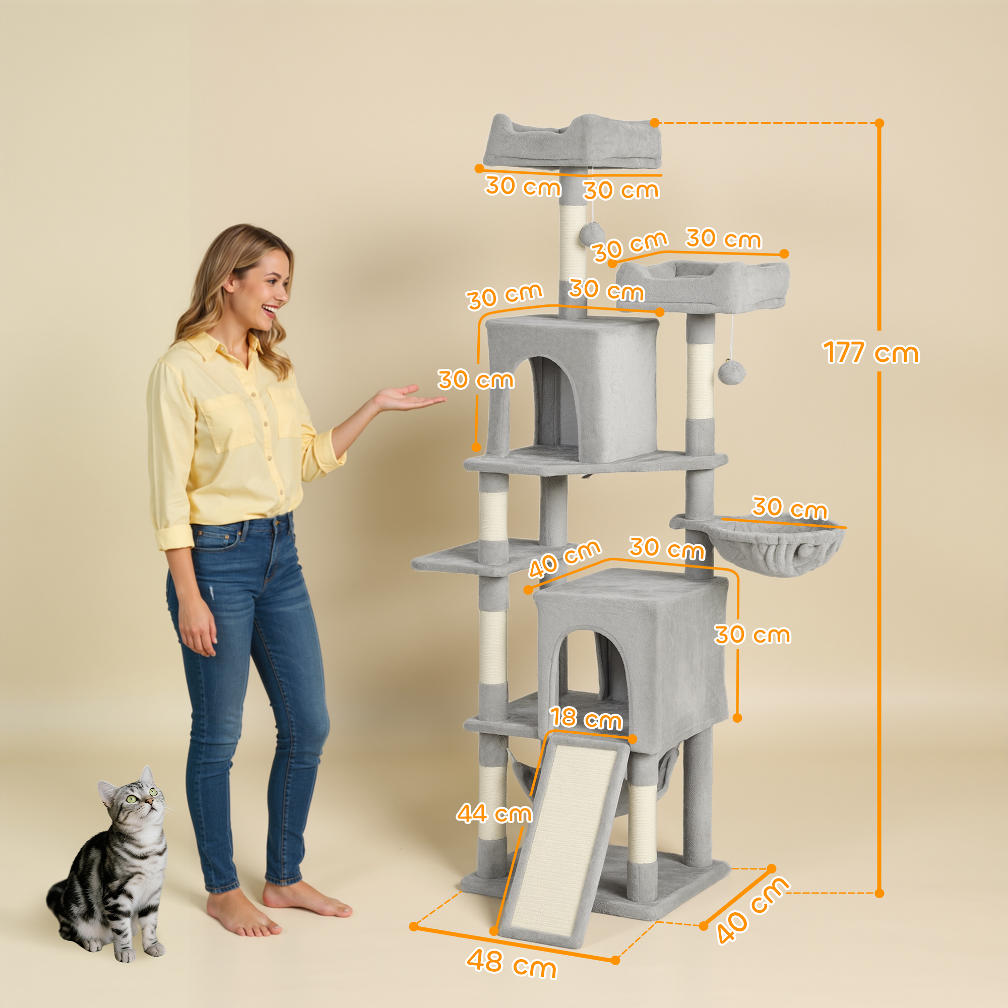 Una donna e un gatto accanto a un tiragraffi alto, grigio e a più livelli.