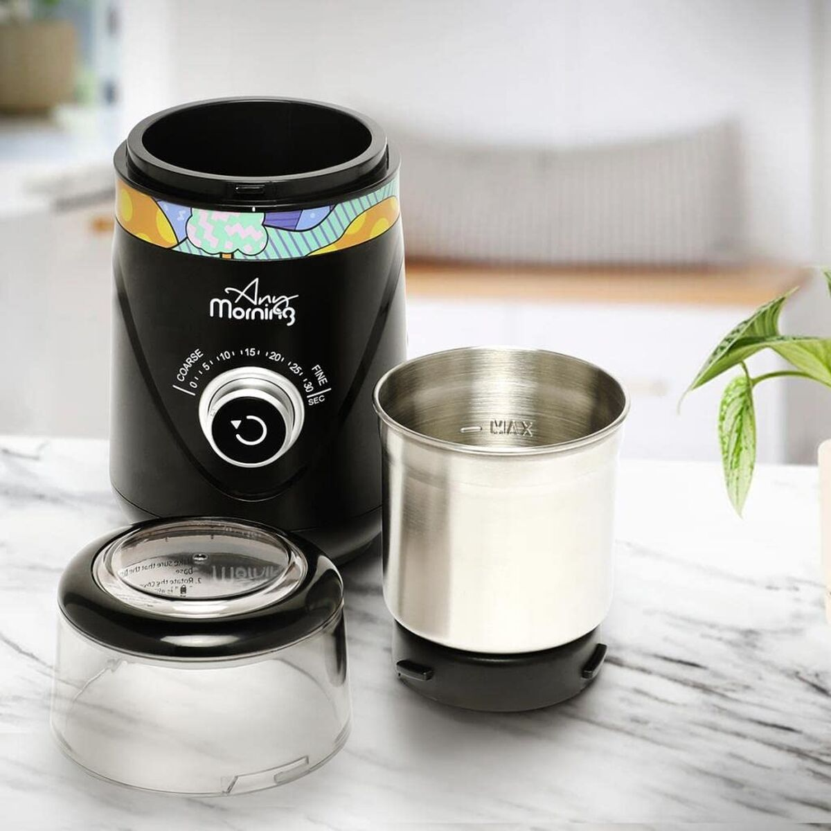Un molinillo de café eléctrico negro con una taza y tapa al lado.
