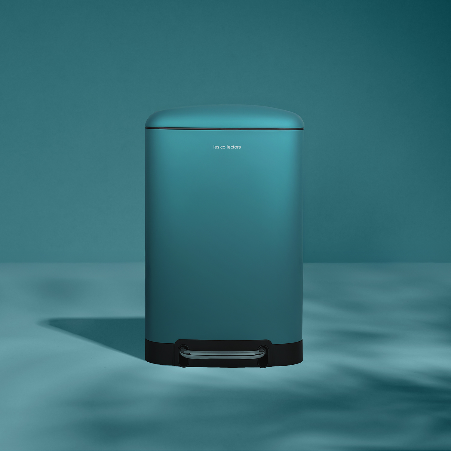 Un cestino a pedale color teal su sfondo teal.