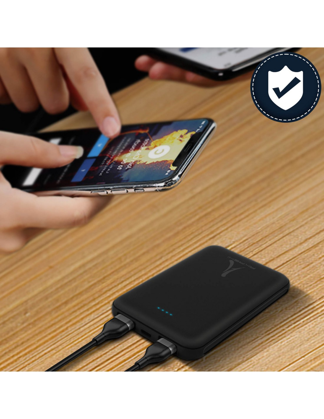 Power bank nero con cavi collegati a due smartphone su tavolo di legno. Icona di sicurezza.