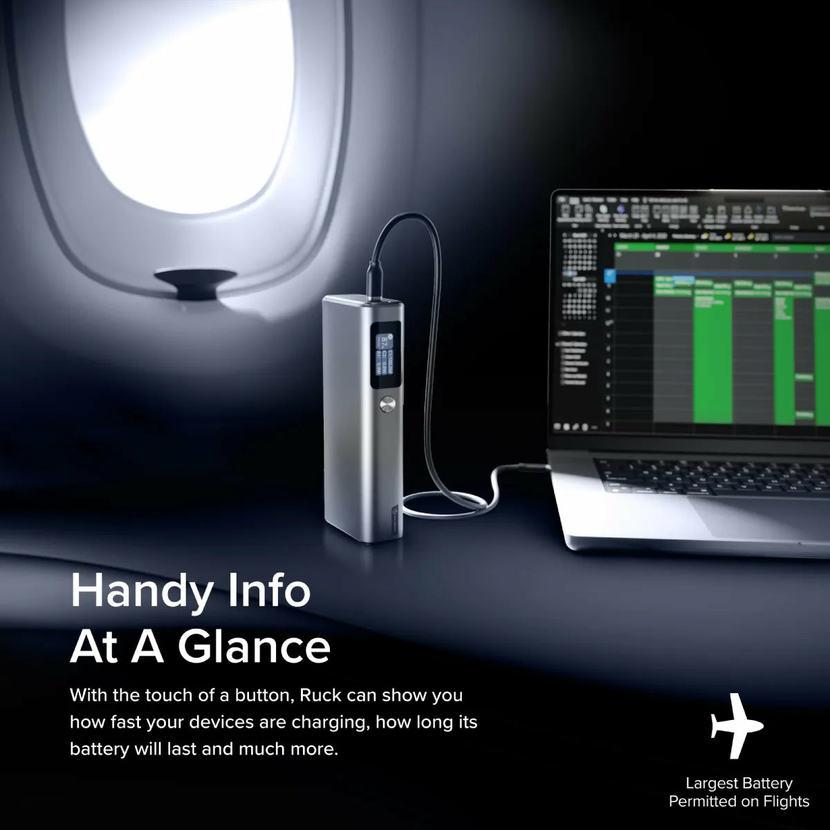 Power bank grigia con cavo collegato al laptop vicino all'oblò dell'aereo.