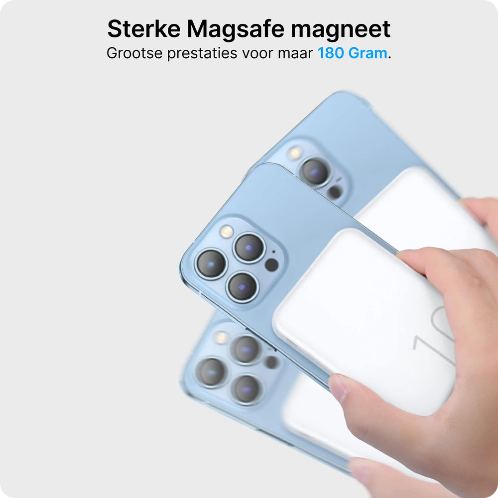 Una mano tiene un caricabatterie MagSafe bianco davanti a due iPhone azzurri.