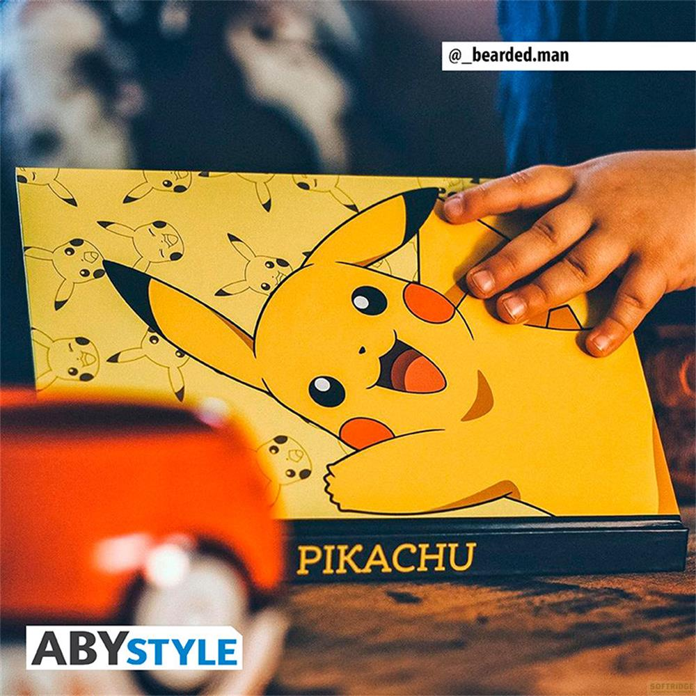 Żółty motyw Pikachu na pudełku z napisem PIKACHU. Dziecięca dłoń trzyma pudełko.