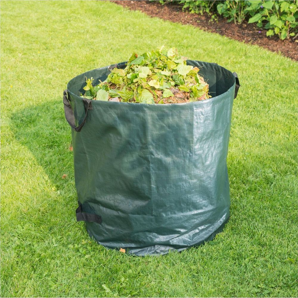Ein grüner Gartensack, gefüllt mit Laub und Zweigen, steht auf einem Rasen.