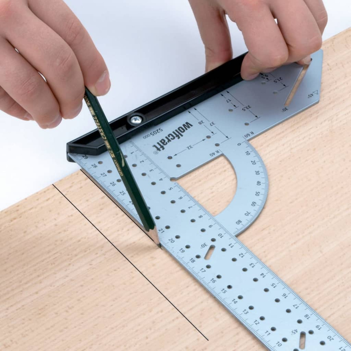 Mani usano una matita per tracciare una linea su legno con un goniometro.