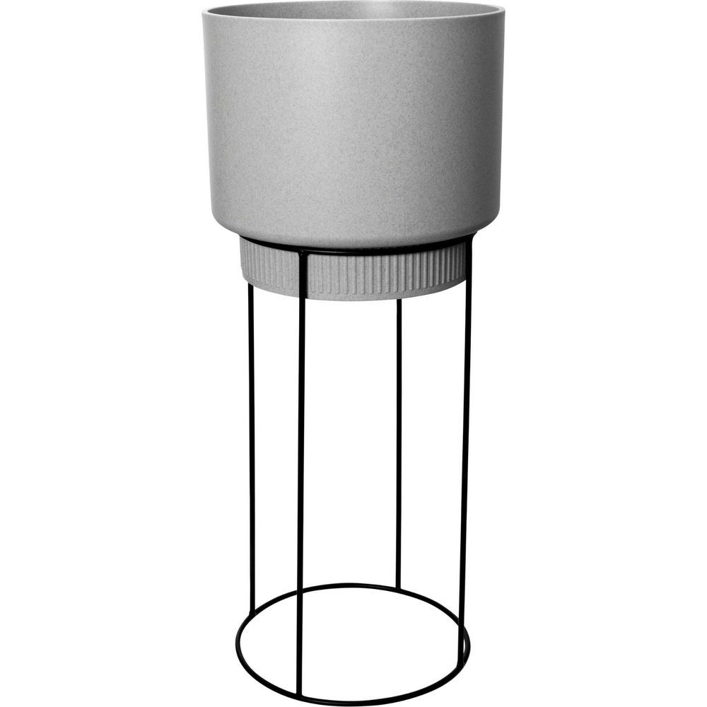 Grauer Blumentopf auf einem schwarzen Metallständer mit drei Beinen.