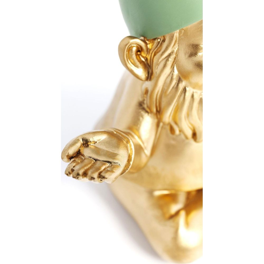 Goldene Figur mit offenem Arm und Hand, grüner Kopf, auf weißem Hintergrund.