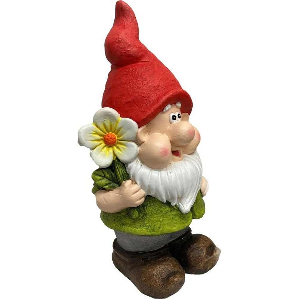 Eine Gartenzwergstatue mit roter Mütze hält eine weiße Blume.