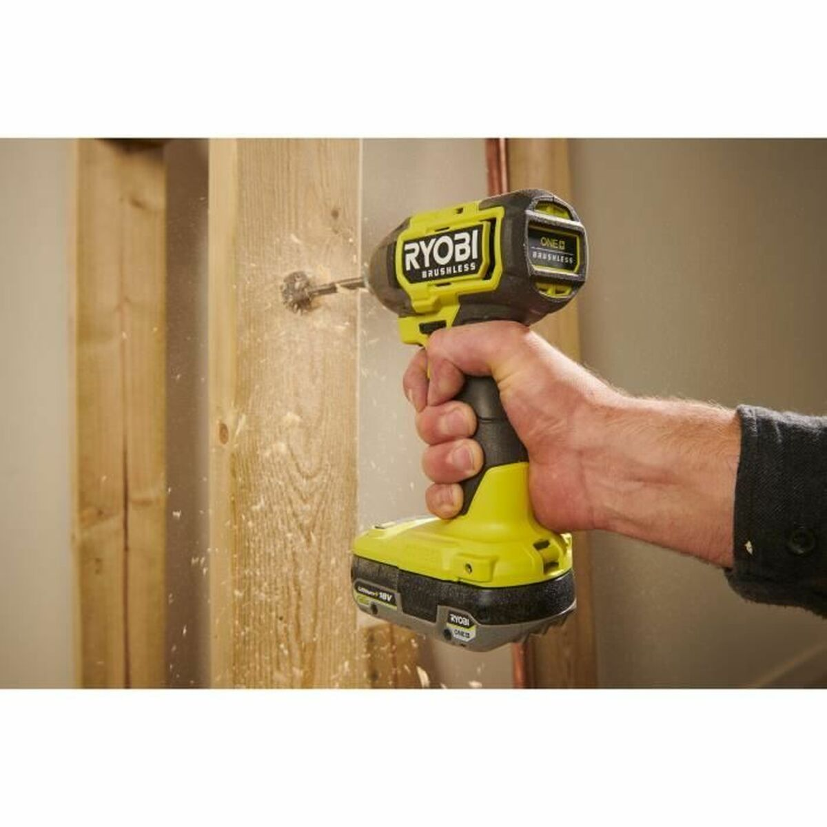 Ein Mann bohrt mit einem gelben Ryobi-Akkuschrauber in Holz.