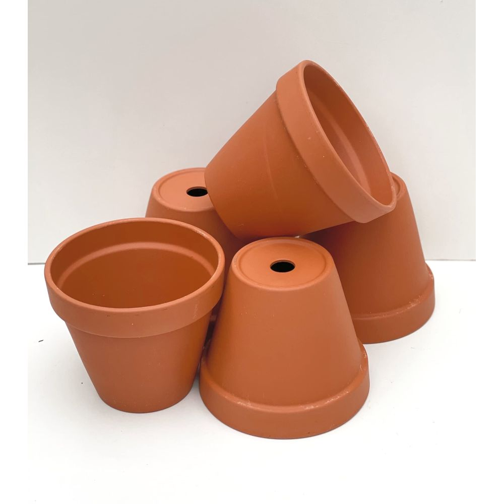 Cinq pots en terre cuite de couleur brune sont empilés, avec un trou au centre.