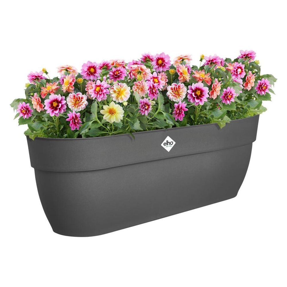 Una fioriera scura piena di fiori colorati rosa, arancio e gialli.